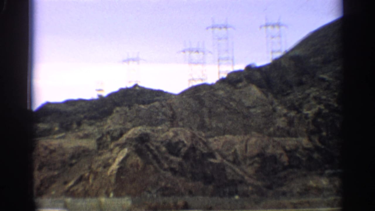 Rocky hills with power transmission towers on the ridge.