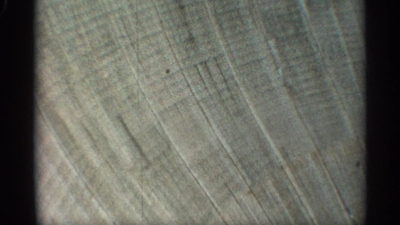 Close view of a textured wall with diagonal grooves and dark film borders.