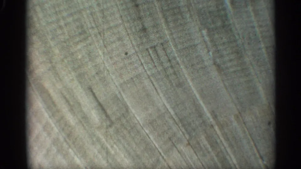 1959 Arizona 8mm frame showing a close, abstract view of a weathered concrete or stucco wall with diagonal surface lines.