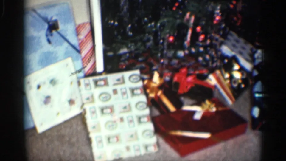 Wrapped presents, holiday cards, and a red gift box sit near the decorated Christmas tree in the 1959 California home interior.