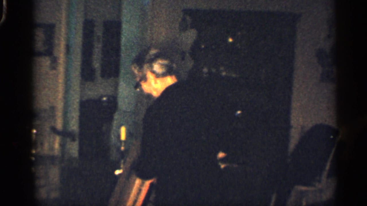 Adult man in a dark shirt moves near a doorway inside a home.