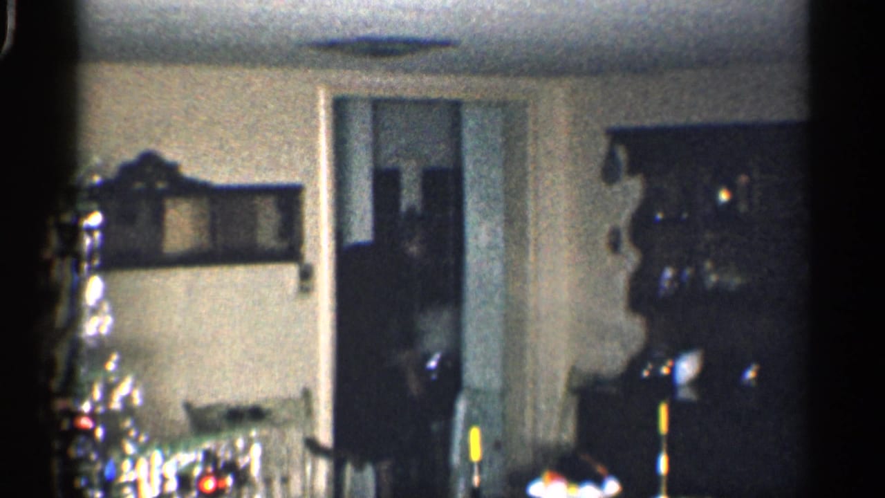 Dim living room with doorway, china cabinet, candles, and holiday decor at the edge of frame.