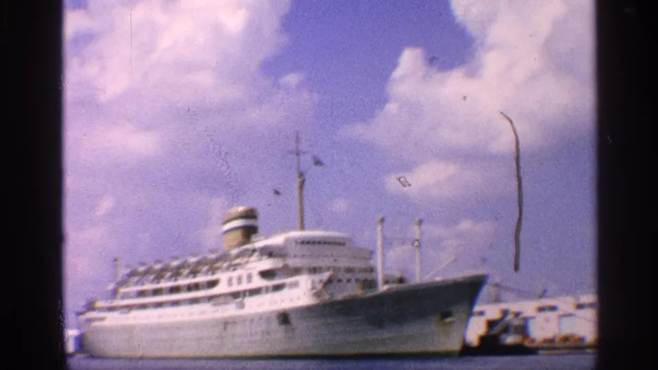 The final frame shows the docked ocean liner at an angle, with blue water, port structures, and visible 8mm surface marks.