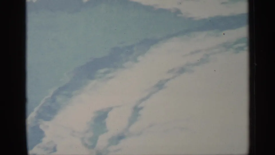 1959 Florida 8mm frame showing a pale water surface crossed by soft blue ripple patterns and film grain.