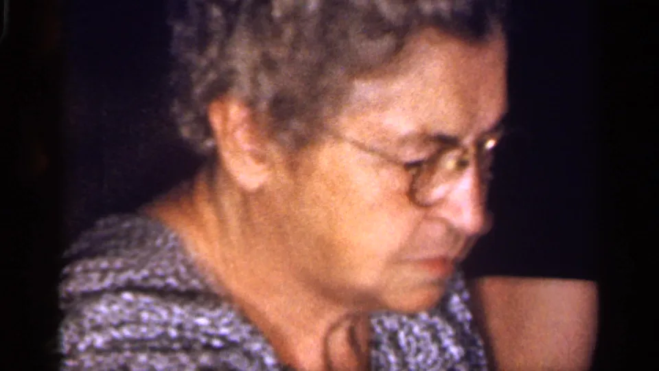 Older woman with gray hair and glasses looks down thoughtfully in warm 8mm home-movie footage from Florida, 1959.