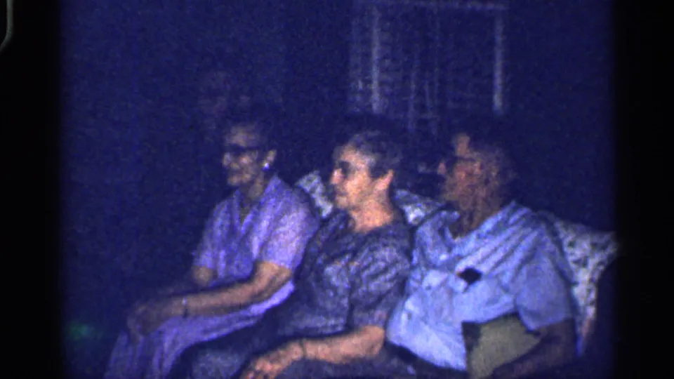 The final 1959 Florida frame shows the couch group in a private living room, with visible faces and heavy 8mm grain.