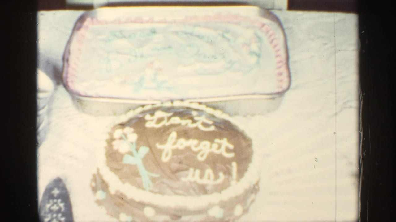 A decorated cake with the message "Don't forget us!" remains centered, with a larger rectangular cake behind it.