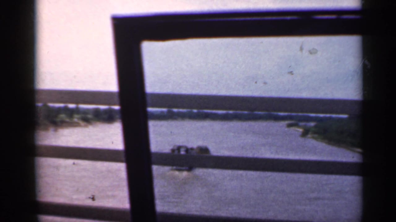 River and shoreline seen through dark window framing.