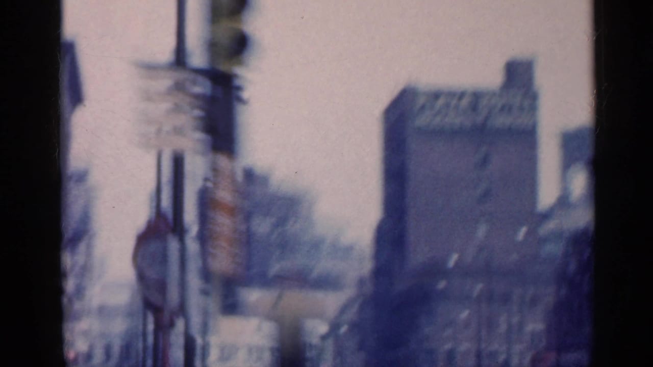 1959 Indiana street view with blurred roadside signs and a prominent building bearing a Plaza Hotel sign.
