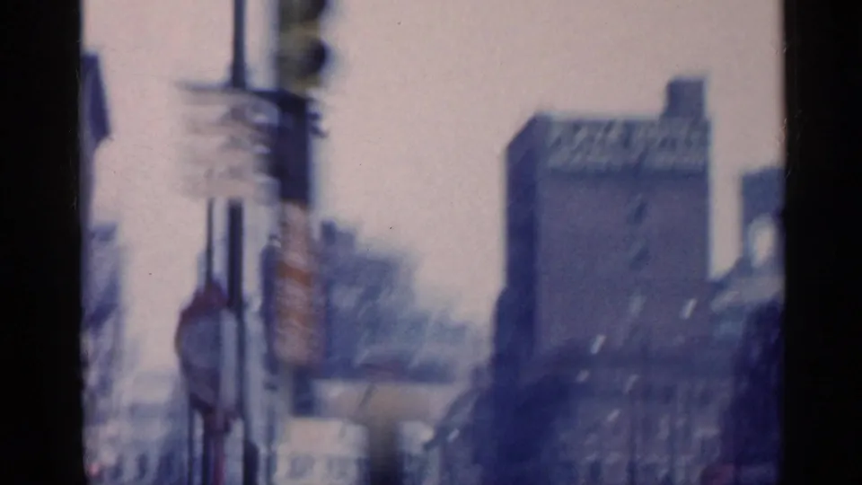 1959 Indiana street view with blurred roadside signs and a prominent building bearing a Plaza Hotel sign.