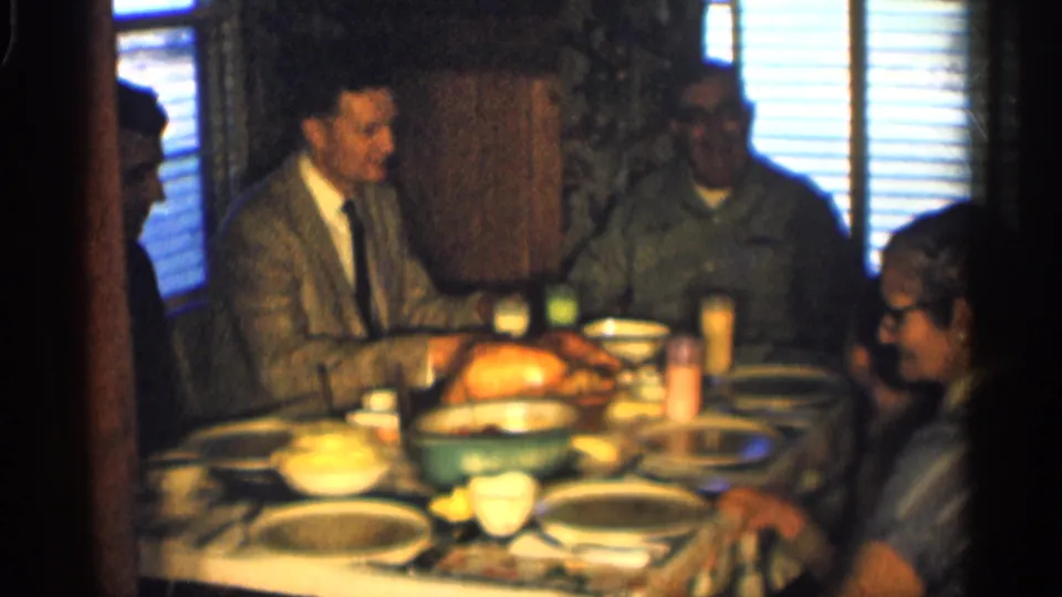 A wider 1959 Indiana dining-room view shows several adult men seated around a family meal table.
