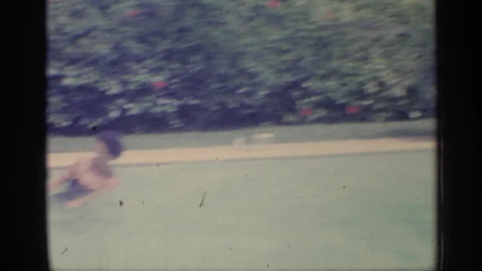Soft 1959 Indiana pool frame with a swimmer moving across the water against a hedge-lined backyard setting.