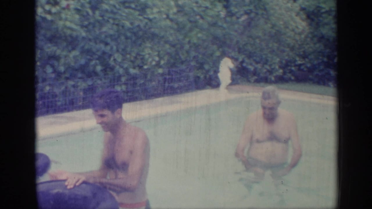 Man holds an inflatable ring while a woman stands in pool water nearby.