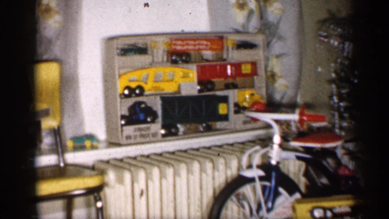 1959 Michigan frame with boxed toy vehicles above a radiator, a child-size bicycle in front, and a decorated Christmas tree at right.
