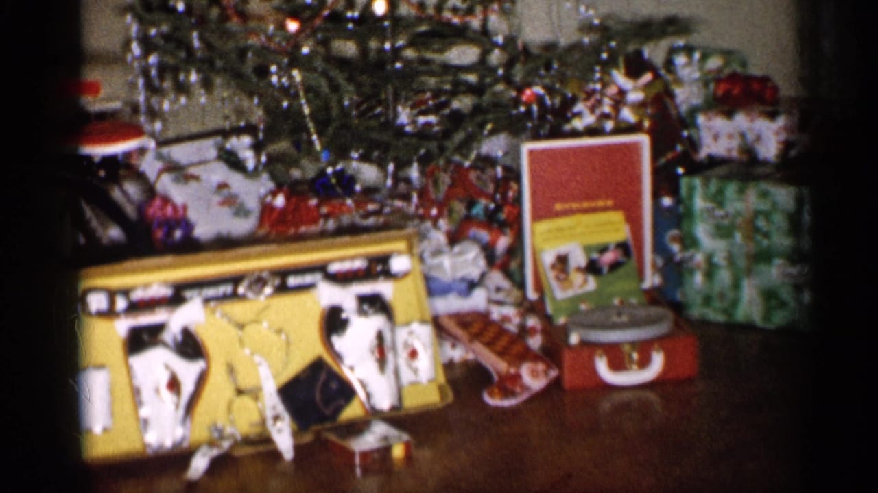 Christmas tree with wrapped presents, toy cash register, and red portable record player.
