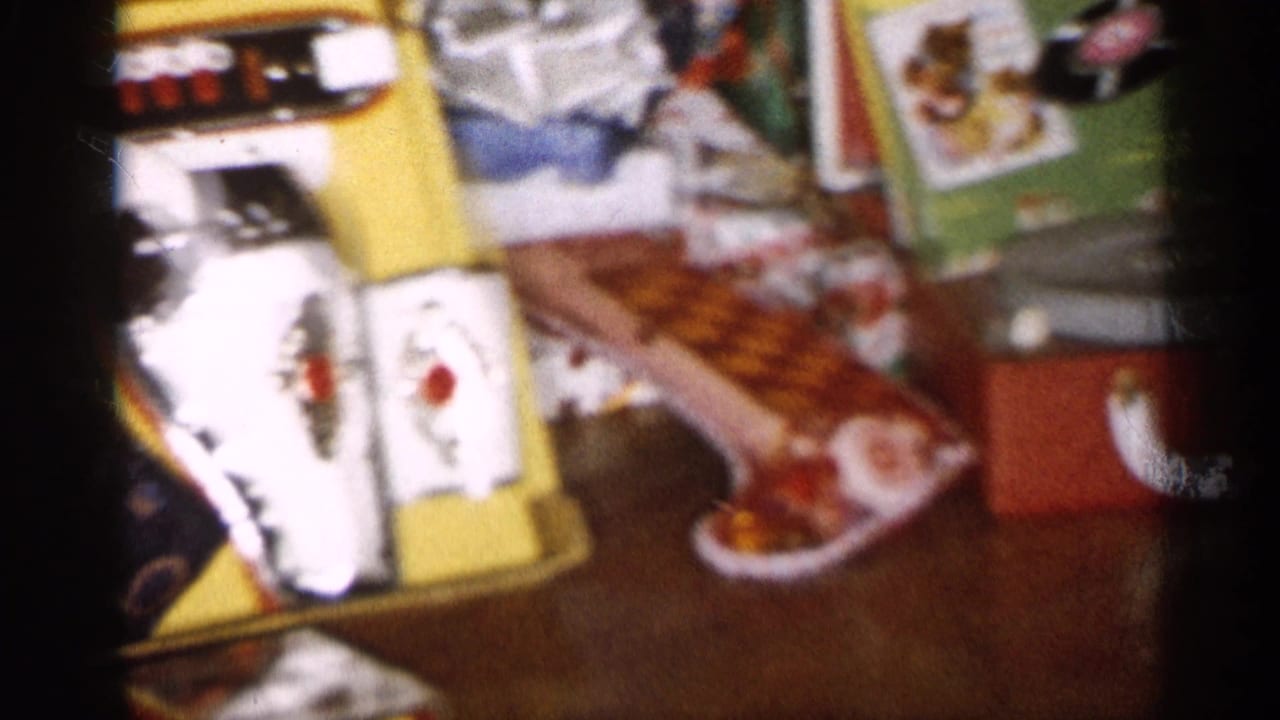 Soft-focus view of wrapped presents, toy set, and stocking near the tree.