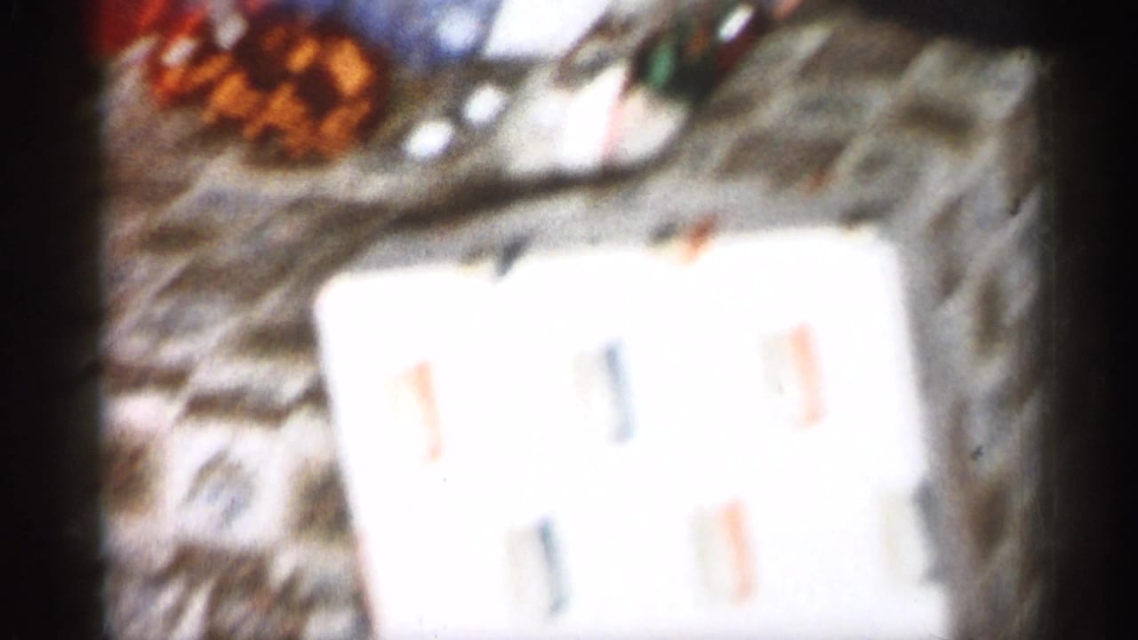 Blurred close-up of wrapped gifts and paper on a wooden floor.