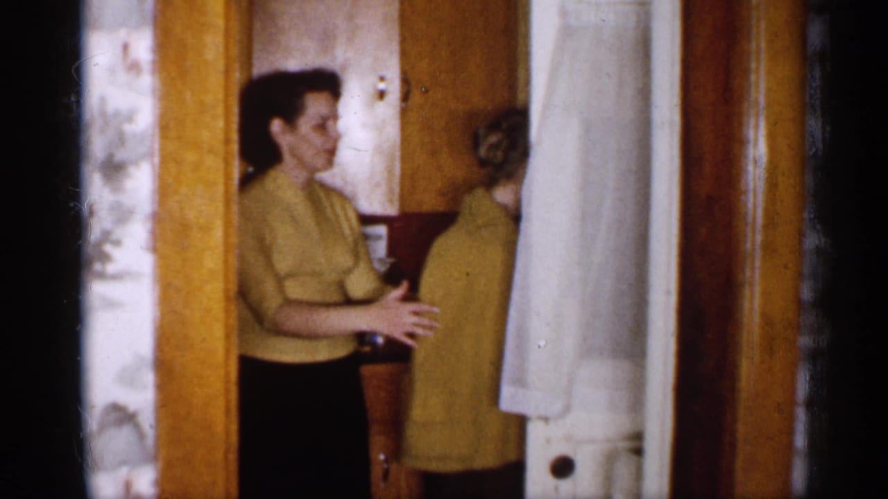 Woman in yellow sweater beside another woman in a vintage kitchen doorway.