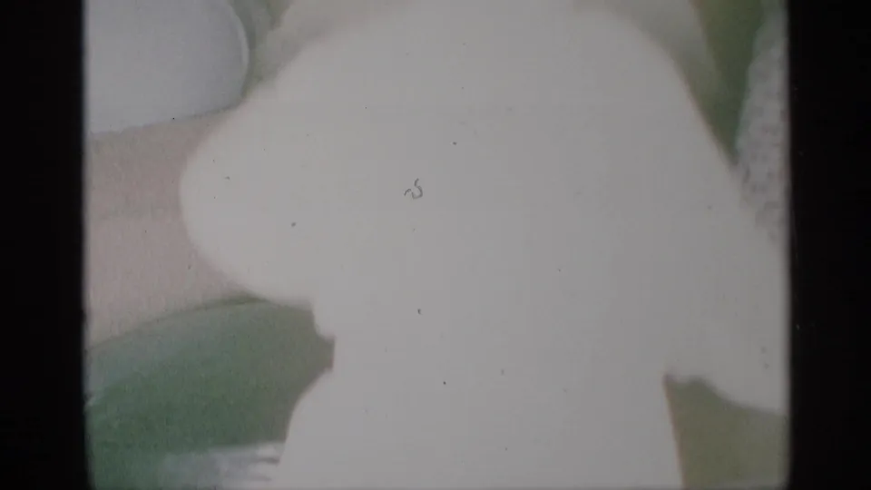 1959 New York 8mm frame showing the child continuing to move or dance in a softly focused domestic interior.