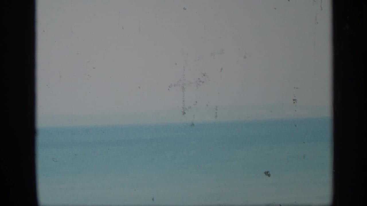 Soft blue ocean horizon divided by a dark vertical bar.