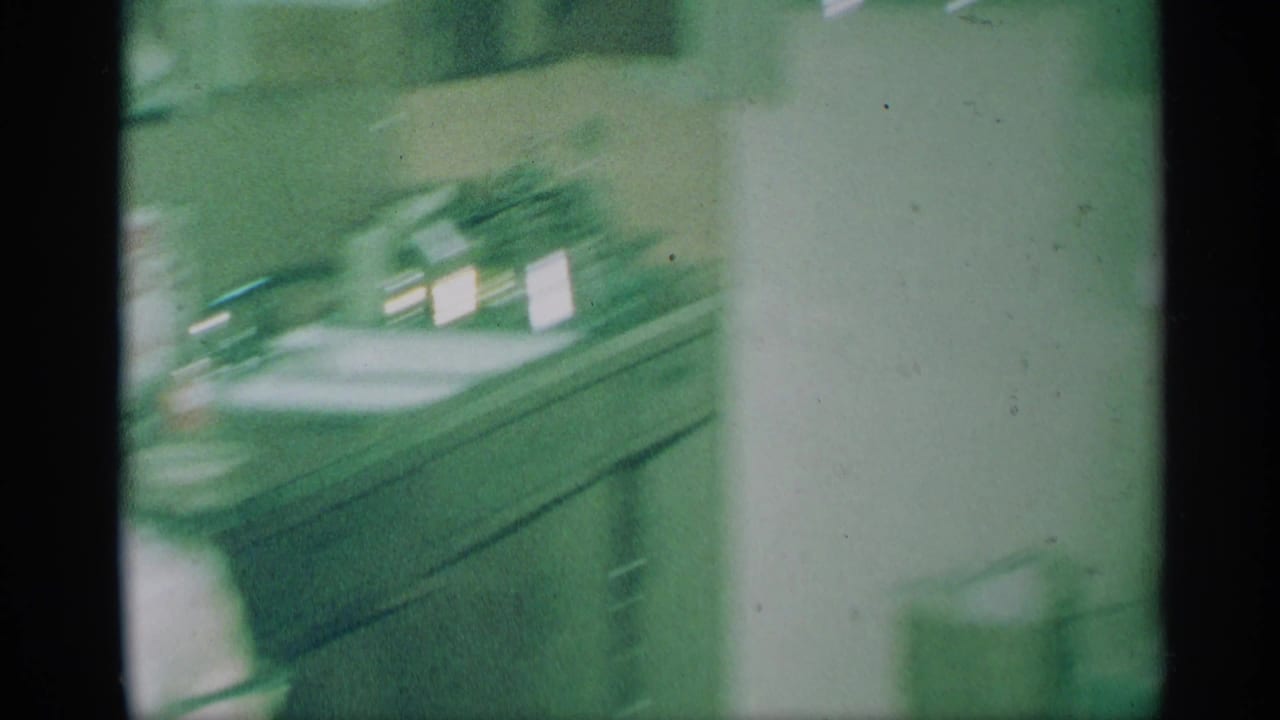 Soft, green-tinted view of a kitchen counter and cabinets through an 8mm film frame.
