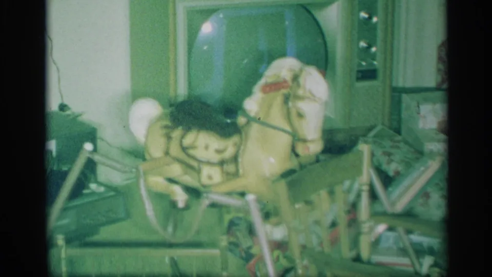 1959 New York home interior showing a child's rocking horse, toy items, a television, curtains, and Christmas decorations.
