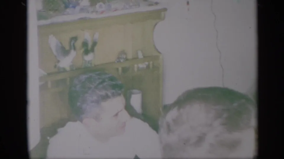 A man in a white shirt sits in a New York holiday interior with a decorated hutch behind him.