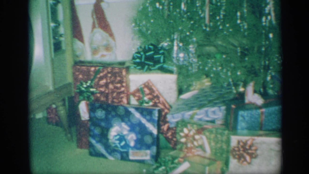 Wrapped Christmas gifts and bows arranged beneath a decorated tree.