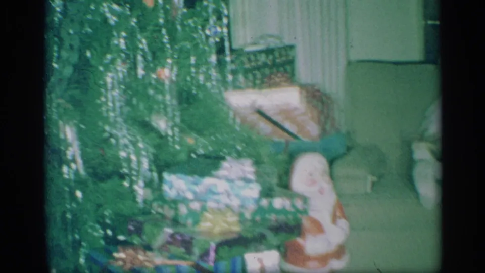 The 1959 New York holiday scene shows a tinsel tree, gifts and a Santa figurine in a private living room.