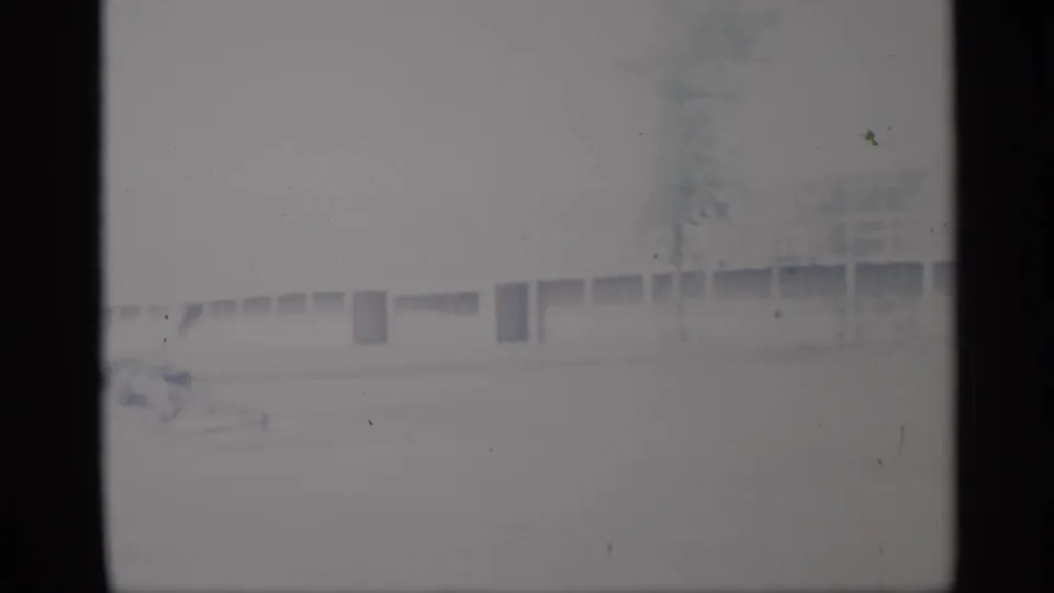 Very pale 1959 New York 8mm frame showing a low exterior building, trees, and dark contact-sheet borders.