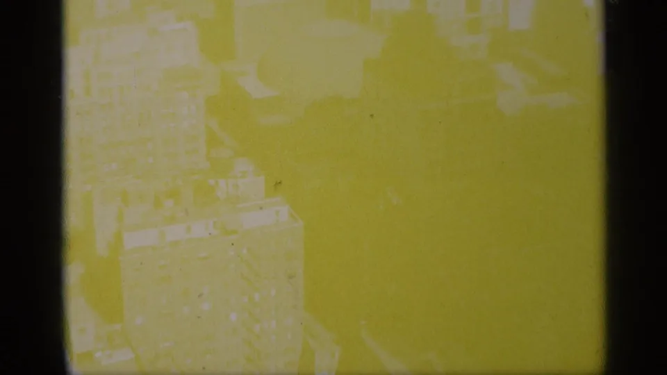1959 New York 8mm frame with heavy yellow-green exposure shift over a downward city view.