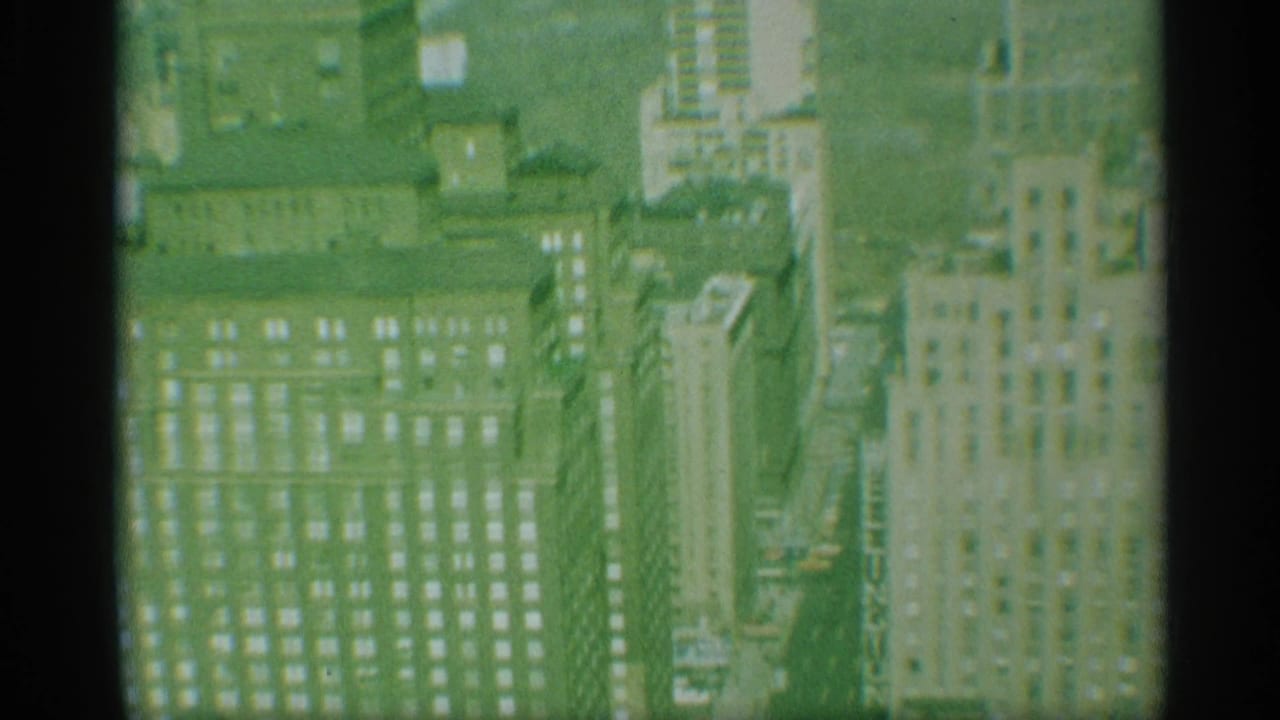 High-angle view of office towers, rooftops, and dense city blocks.