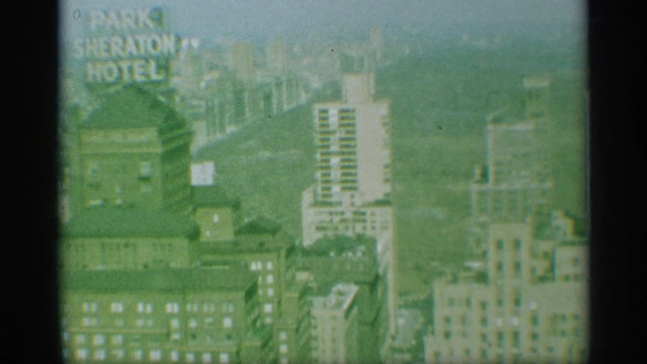 1959 New York home-movie view of high-rises with partial Sheraton Hotel signage visible through soft, green-tinted film.
