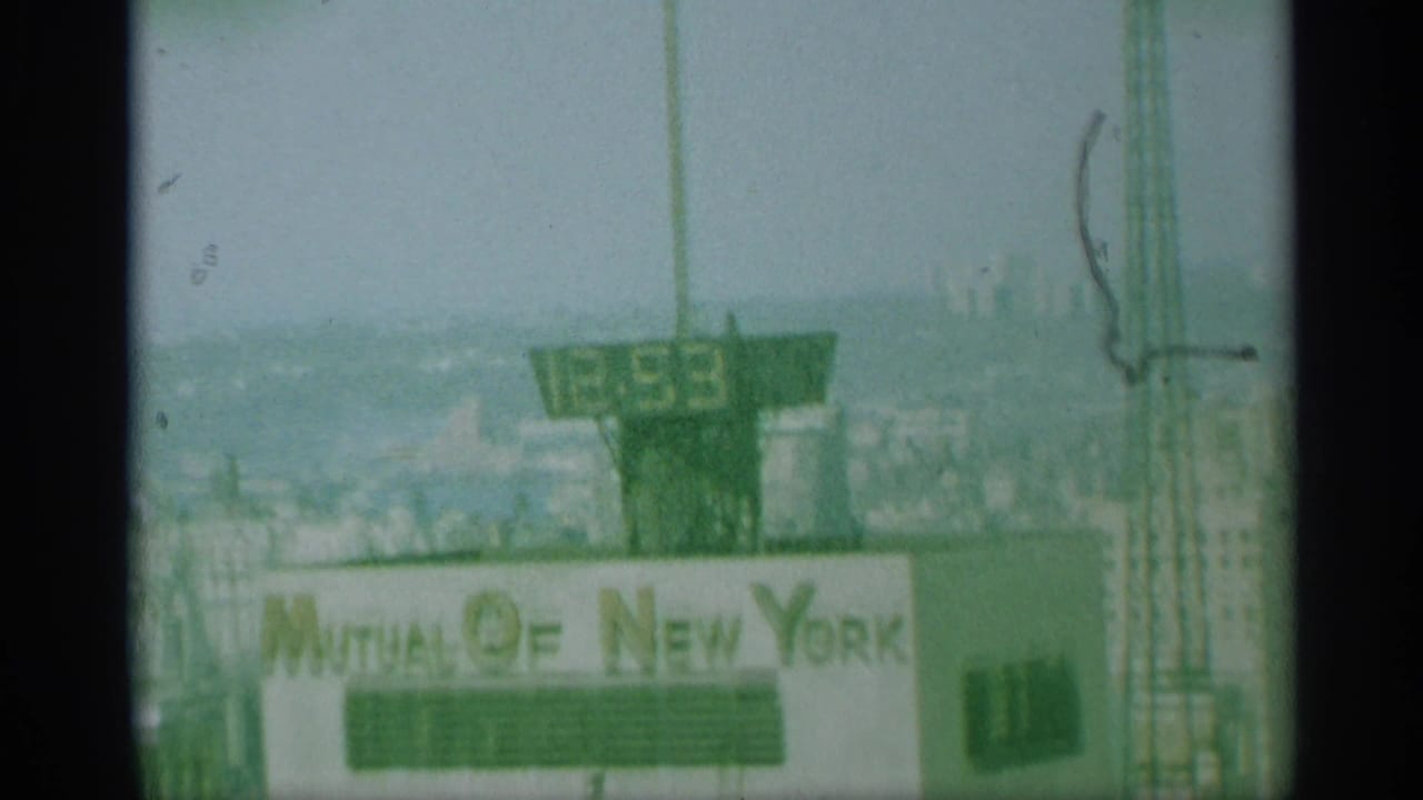 Soft green-tinted view of the Mutual of New York building top and rooftop clock.