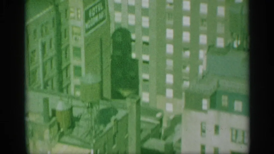 1959 New York 8mm frame showing a soft aerial view of high-rise buildings, windows, and rooftop structures.