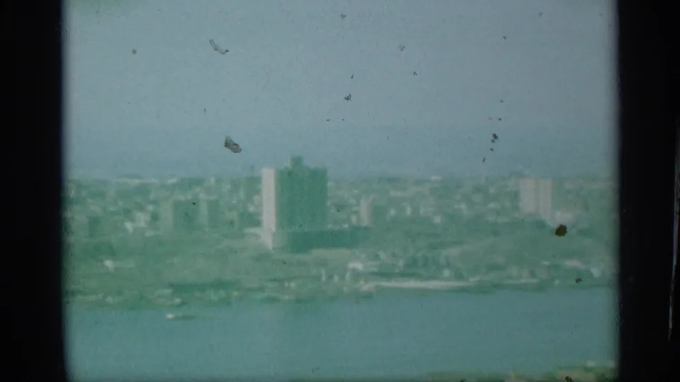 1959 New York aerial footage appears to show waterfront buildings across a wide river, with a tall rectangular tower in the distance.