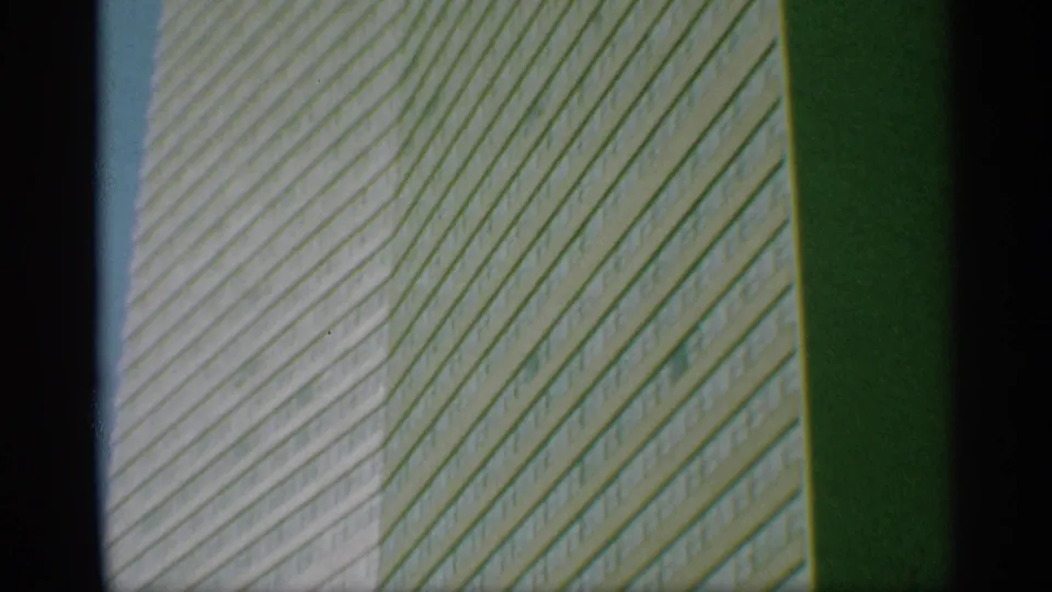 1959 New York frame showing the high-rise exterior more tightly, with dense window rows and a dark vertical film edge.