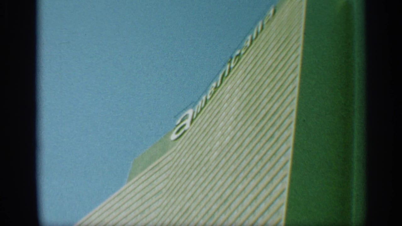 1959 New York 8mm frame showing the striped skyscraper facade from below, with partial letters along the upper edge.