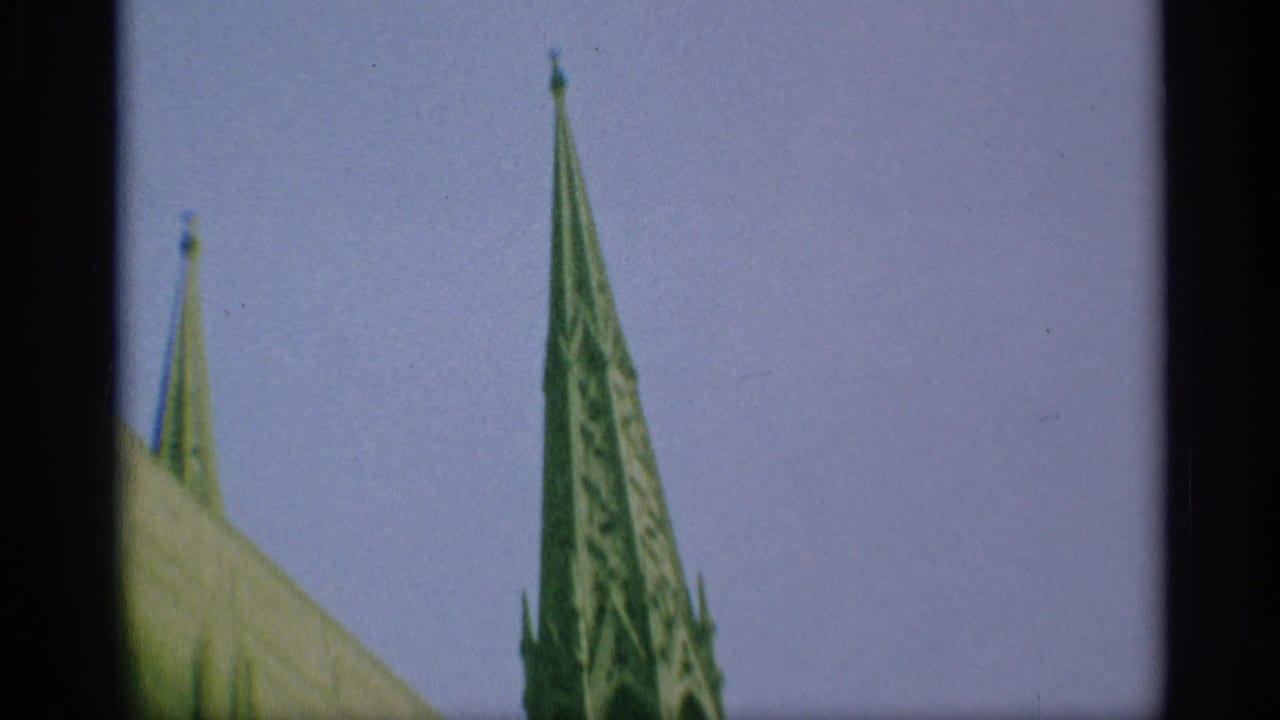 1959 New York home-movie frame with two Gothic spires visible above the cathedral roofline.