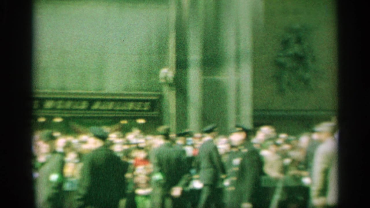 1959 New York street-event view with suited spectators and uniformed officers outside a large building.