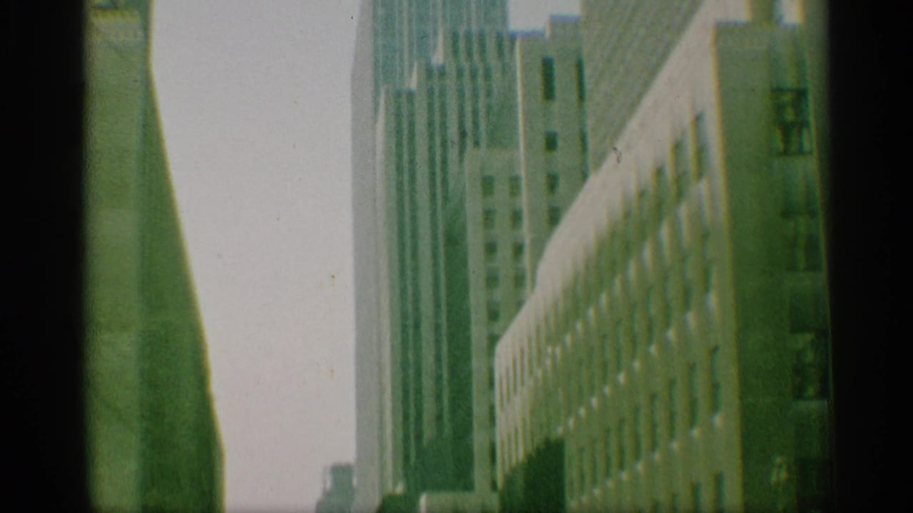 1959 New York view of high-rise facades, with a long building wall leading into the distance.