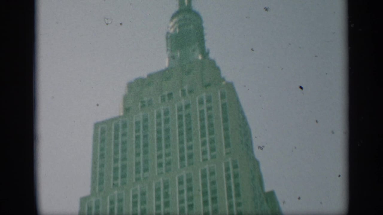 1959 New York frame showing the Empire State Building's upper windows, stepped crown, and spire in soft 8mm color.
