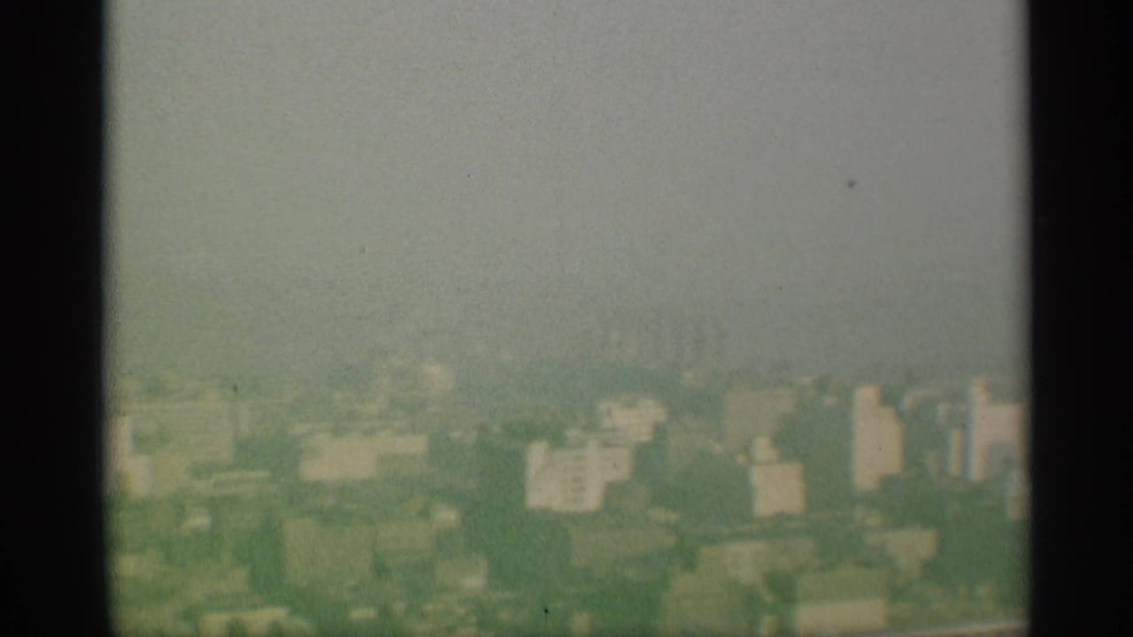 Hazy New York city skyline in 1959 home-movie footage, partially obscured by fog and soft focus.