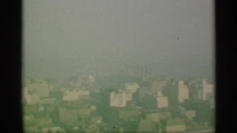 Hazy New York city skyline in 1959 home-movie footage, partially obscured by fog and soft focus.