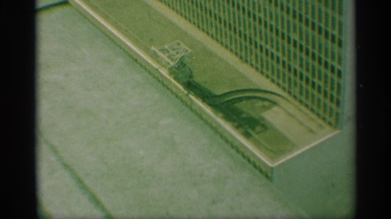 High-angle view of a gridded building facade beside water or a flooded surface.