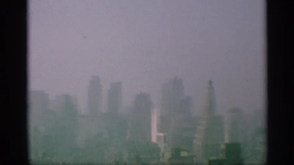 Late-1950s New York skyline view with softened high-rises and a tall rooftop or column-like structure visible at the right edge.