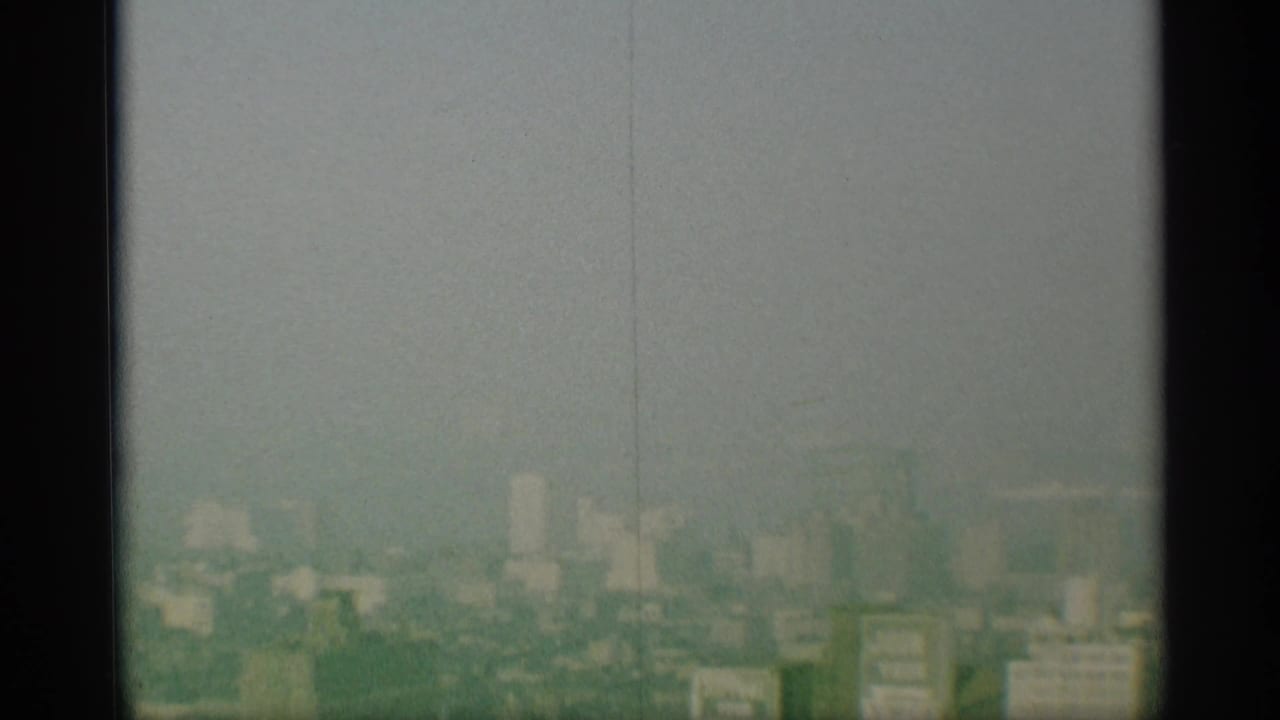 A faded 1959 New York skyline view appears partially obscured by dark vertical framing and film haze.
