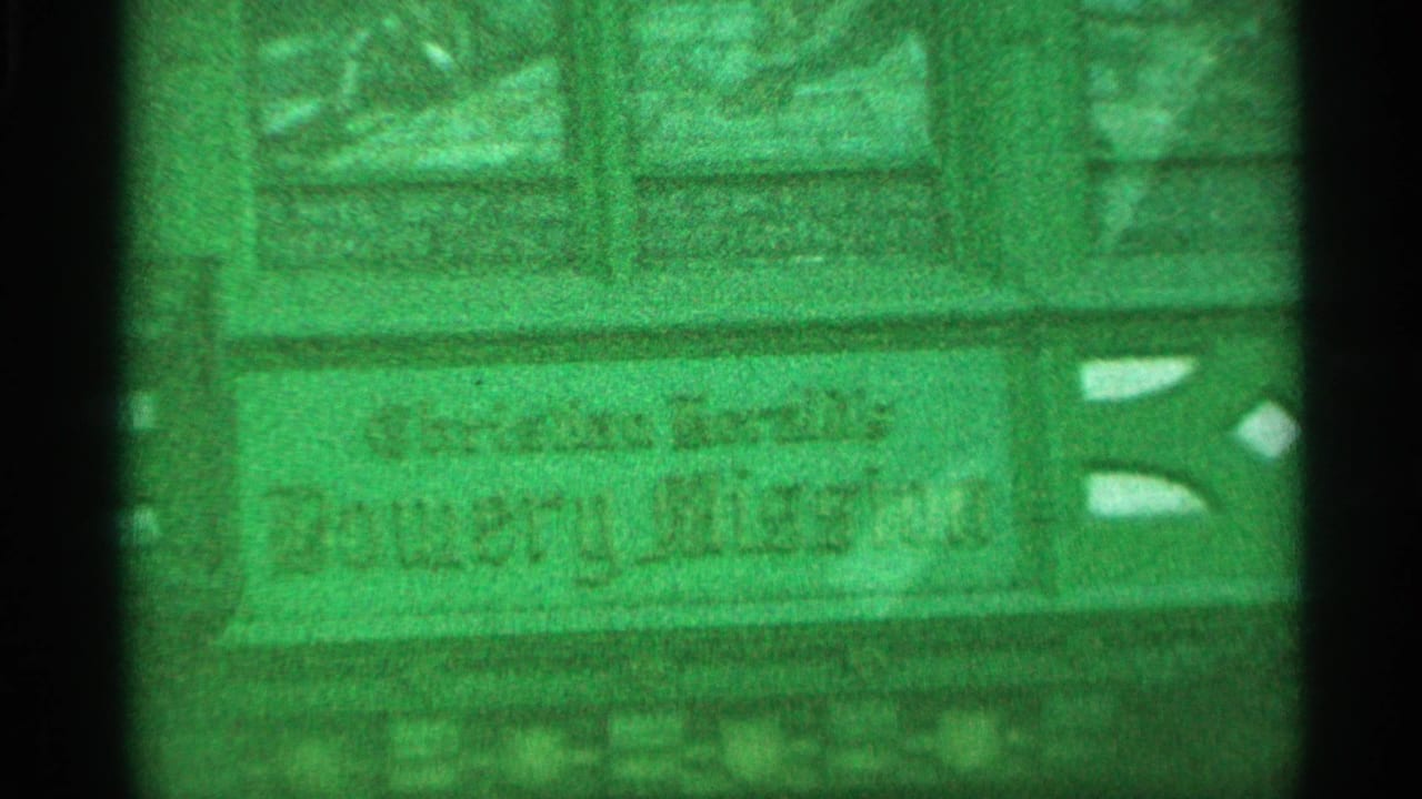 Green-tinted close view of a building sign or facade lettering.