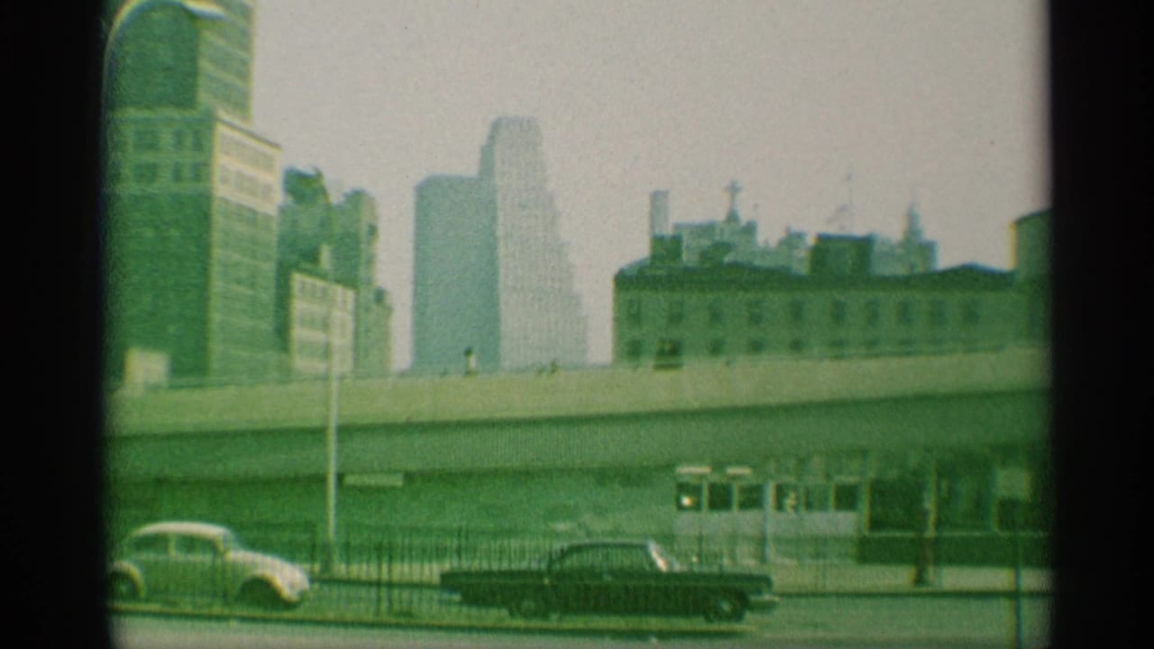1959 New York cityscape with an elevated roadway, soft high-rises, fencing, and mid-century cars on the street below.