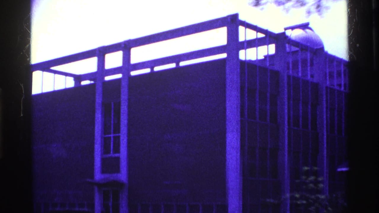 1969 Ohio 8mm frame showing a blue-tinted modernist building exterior with vertical supports, tall windows, and dark edge framing.